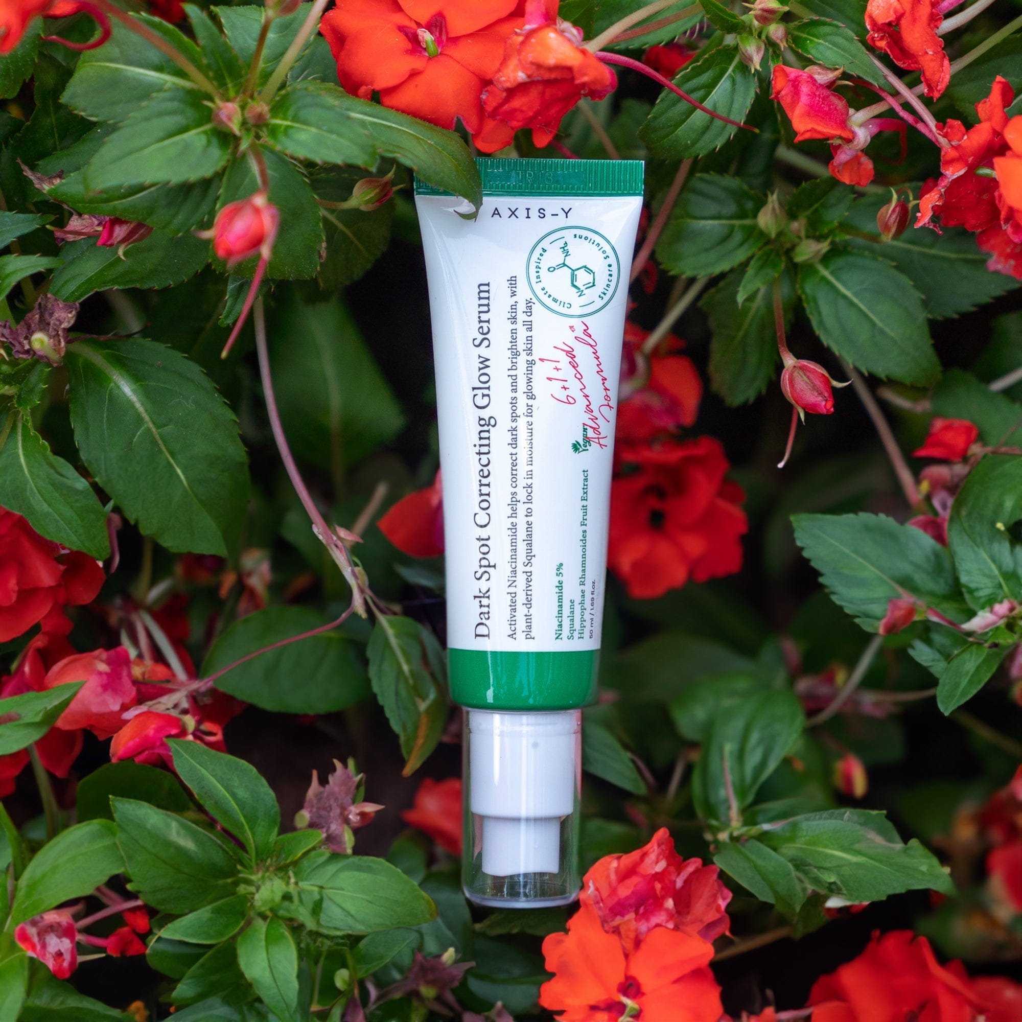 Photograph of Axis Y Dark Spot Correcting Glow Serum in a bed of flowers